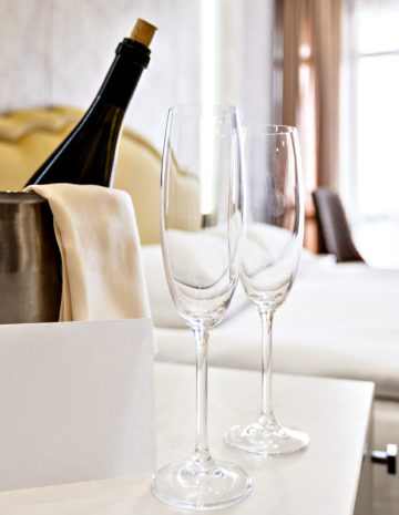 Honeymoon concept. Champagne bucket near bed in a hotel room